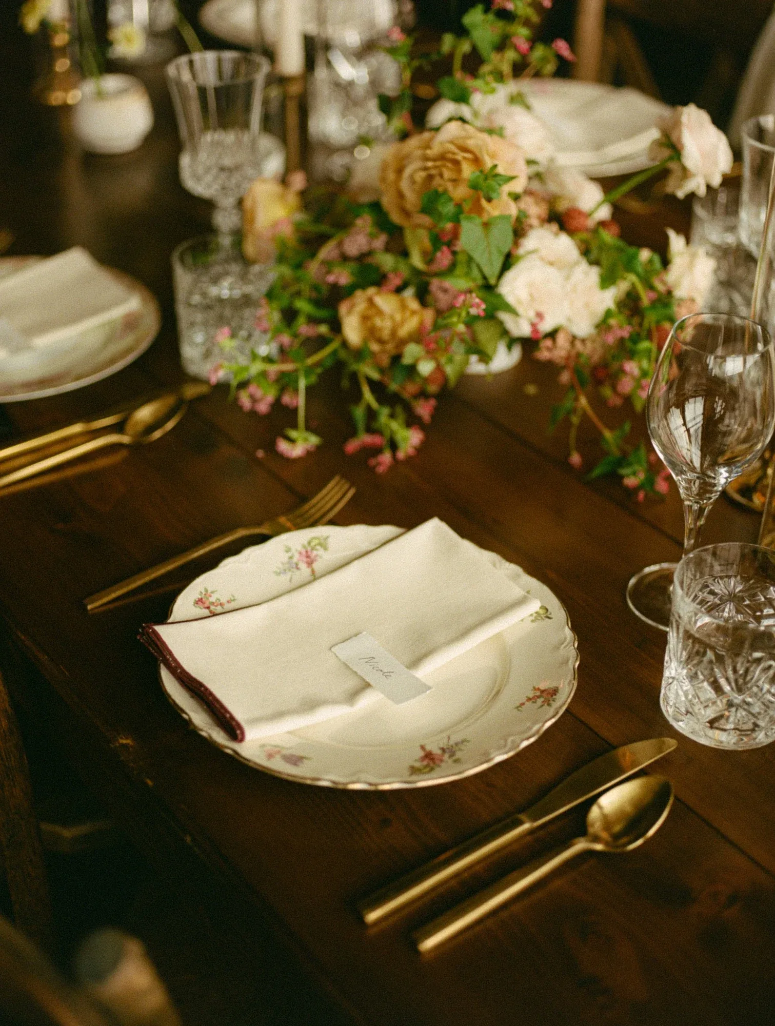A candlelit table of vintage china, crystal and loose garden flowers